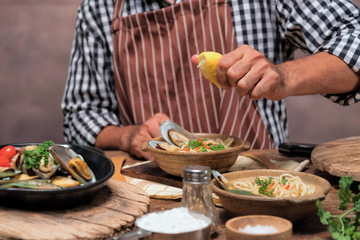 Wall Mural - Handsome bearded cheef cook prepairing spaghetti on a kitchen.