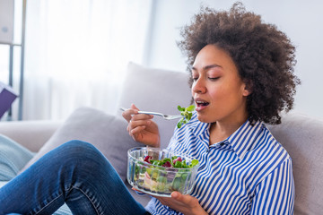 Wall Mural - Close-up Of Beautiful African American Woman Eating Salad At Home