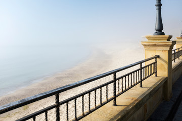 Wall Mural - fog on the beach in spring day with metal border on embankment in Odessa