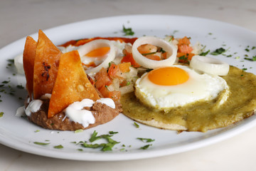 Wall Mural - Huevos divorciados, fried eggs on corn tortillas with salsa verde and roja, mexican breakfast