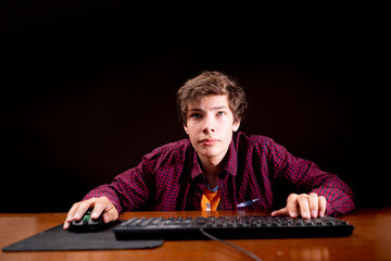 Wall Mural - young male playing computer video games on a table in a dark room b