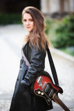 Fototapeta Młodzieżowe - young brunette woman with guitar on the street