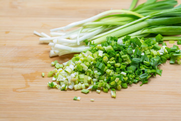 Chopped green garlic on cutting board preparated for cooking.