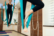 © Kate - closeup woman legs in hammock for fly yoga exercises. Woman doing fly yoga stretching exercises in gym. Fit and wellness lifestyle