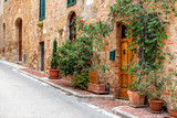 Fototapeta Uliczki - San Quirico D'Orcia, Italy Street empty road in small historic medieval town village in Tuscany during summer day stone architecture and garden