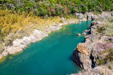 Wall Mural - Emerald blue and green Hida river high angle aerial view perspective in spring springtime near Gero Onsen town in Gifu prefecture in Japan