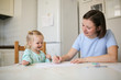 © natalialeb - mother and daughter together at table in kitchen