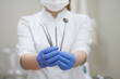 © Juli Puli - dental instruments in the hands of blue gloves on the background of a medical suit