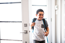 A Child Boy Coming Home Passing Through The Door After School