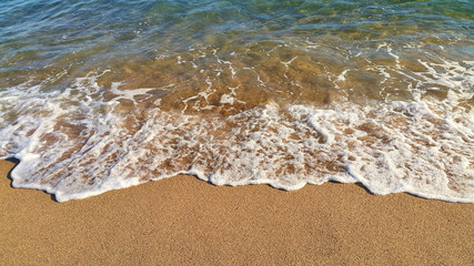 Wall Mural - Sea wave with white foam on the sandy beach