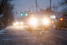 Car Driving On Snowy Urban Street At Night