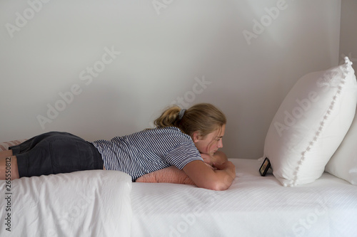 13 Year Old Girl Lying On Bed Watching Her Smart Phone Buy