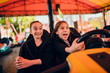 © kerkezz - Girlfriends in amusement park driving bumper car