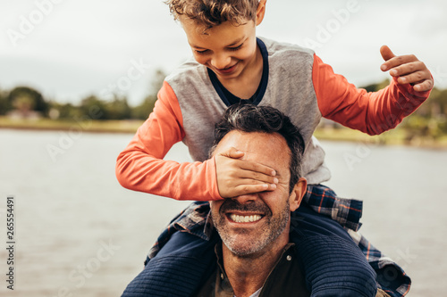 Father and son playing near the lake Poster Mural XXL