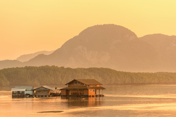 Wall Mural - Beautiful sunrise landscape view of fisherman village and wooden boat in early morming at Samchong-tai fishing village in Phang-Nga,Thailand