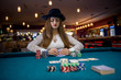 © RomanR - Woman in hat with playing cards and poker chips in casino
