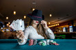 © RomanR - Woman in hat with playing cards and poker chips in casino