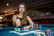 © RomanR - Beautiful woman in casino taking chips from pile
