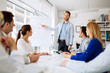 © NDABCREATIVITY - Group of business people working as team in office