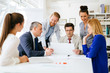 © NDABCREATIVITY - Group of business people working as team in office