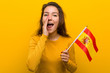 © Asier - Young european woman holding a spanish flag shouting excited to front.
