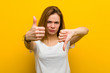 © Asier - Young natural caucasian woman showing thumbs up and thumbs down, difficult choose concept
