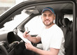 © Pixel-Shot - Handsome delivery man sitting in car