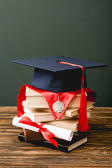 Wall Mural - books, academic cap, medal and diploma on wooden surface isolated on grey