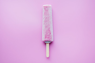 Bright fruit ice cream on a stick on a pink background. Frozen fruit ice. Summer mood. Cooling dessert in hot weather. Favorite delicacy for children. Homemade raspberry, strawberry, watermelon ice