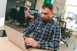 © wpadington - Young bearded man using his laptop at the coworking