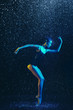 © master1305 - Young female ballet dancer performing under water drops and spray. Caucasian model dancing in neon lights. Attractive woman. Ballet and contemporary choreography concept. Creative art photo.