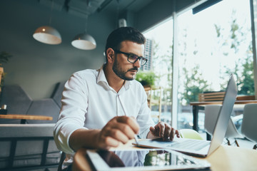 Attractive man working in cafe 