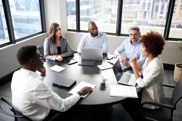 elevated view of corporate business colleagues talking in a meeting room