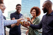 © Monkey Business - Smiling creative business colleagues drinking after work raising glasses to make a toast