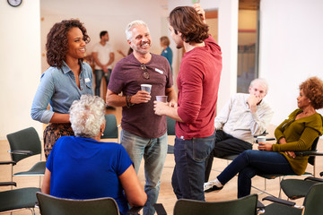group of people socializing after meeting in community center