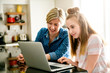 © Louis-Paul Photo - A mother using a laptop in kitchen with teenager