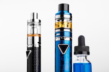 Wall Mural - Electronic cigarettes and bottle with vape liquid on white background