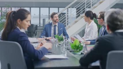 Wall Mural - In the Corporate Meeting Room Close-up on the Hands of Businesspeople, Signing Contracts, Using Smartphones and Digital Tablet Computers, Gesticulating. People Sitting at Conference Table