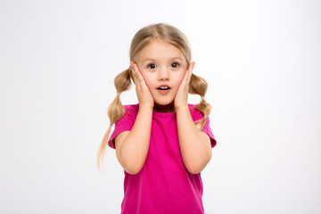 baby girl blonde girl in pink t-shirt on white smiling background.Charming slim girl with long tails on the head and a pink T-shirt. Close-up-Isolated on white background