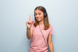 © Asier - Young pretty caucasian woman showing number one. She is listening to music with headphones.
