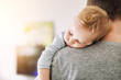 © Kirill Gorlov - Close-up portrait of cute adorable blond caucasian toddler boy sleeping on fathers shoulder indoors. Sweet little child feeling safety daddys hand. Responsibility and childcare. happy childhood