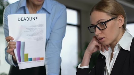 Wall Mural - Angry female boss shouting at guilty worker holding deadline document, stress