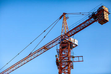 Construction crane tower on blue sky background.