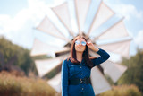 Fototapeta Młodzieżowe - Trendy Female Tourist Standing in Front of Windmill
