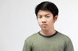 © sirikorn - Portrait Young Asian boy over gray background, be upset; have a bad temper emotional portrait of teen boy wearing t-shirt. Thoughtful teenager, isolated on white background.