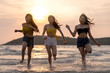 © ChayTee - Group of Three asian beautiful attractive young woman playing and running on the beach at the sea. Group of happy friends runs to the sea with tropical beach at sunny evening. Beach holidays concept