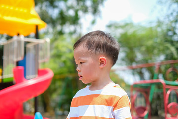 Cute little Asian 2 - 3 years old toddler baby boy child sweating during having fun playing, exercising outdoor at playground on nature at park, Heat stroke and summer sunstroke risk symptom concept