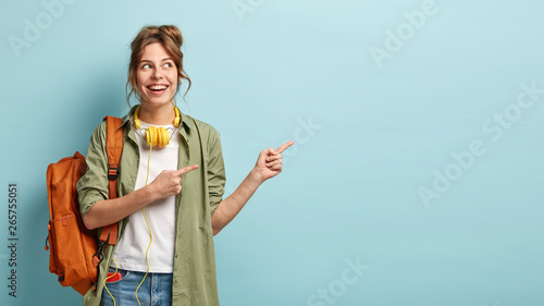 Fotografía Positive European female teenager uses modern technologies for entertainment, po