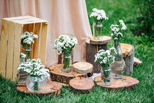 Wedding Decorations And Arch. Jars With Flowers. Rustic Wedding Decoration With Flowers. Old Wooden Style. Romantic Picnic In Nature
