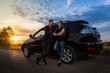 © keleny - Couple standing near the car in a summer evening